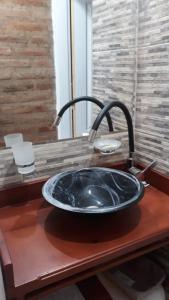 un lavabo con un gran fregadero negro en Complejo Puesta del Sol san Luis en La Punta