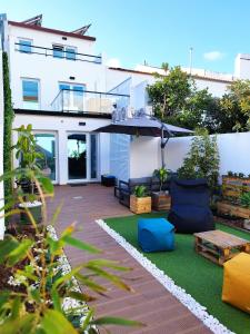 een achtertuin met een patio met een parasol en meubilair bij Santa Alegria Hostel in Ponta Delgada