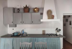 une cuisine avec des placards blancs et un comptoir dans l'établissement Pias Baixinho, à Pias