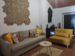 ein Wohnzimmer mit einem Sofa und einem Stuhl in der Unterkunft Pias Baixinho in Pias