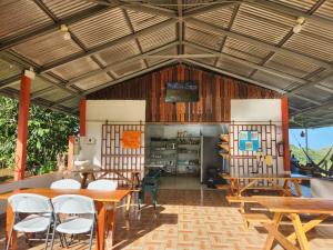 uma sala de jantar com mesas e cadeiras de madeira em La Piña, Rio Celeste em Rio Celeste