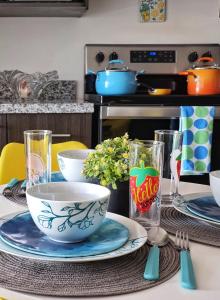 a table with plates and bowls on top of it at Avitat Joy Cozy&Homy 2B Flat Private Wifi Pool Gym in San Salvador