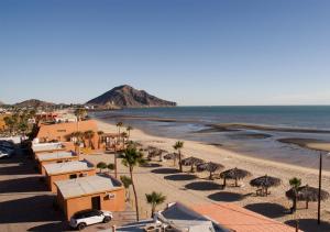 a beach with palm trees and buildings and the ocean at Stella del Mar in San Felipe