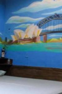- un lit orné d'une peinture murale dans l'établissement Hostel swellpipa, à Pipa