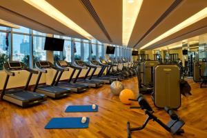 une salle de sport avec une rangée de tapis roulants et d'appareils d'exercice dans l'établissement Fashion Avenue Dubai Mall Highest Floor Burj Khalifa View Residence- Formerly Address Dubai Mall, à Dubaï