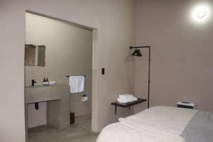 a bathroom with a bed and a sink and a mirror at Lereko Bush Villa in Marloth Park +23 photos