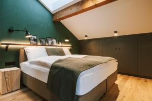 a bedroom with a large bed with a green wall at Hotel Fiescherblick in Grindelwald