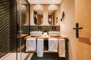 Baño con 2 lavabos y espejo en Hotel Fiescherblick en Grindelwald