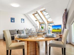 een eetkamer met een tafel met stoelen en een laptop bij Haus Seeblick Maritim in Am Schwarzen Busch