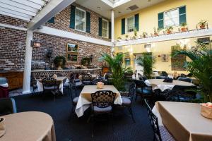 a restaurant with tables and chairs and a brick wall at The Marshall House, Historic Inns of Savannah Collection in Savannah