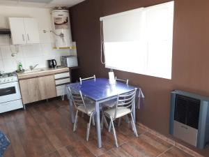 una cocina con una mesa azul y sillas. en alquilerpordiviedma en Viedma