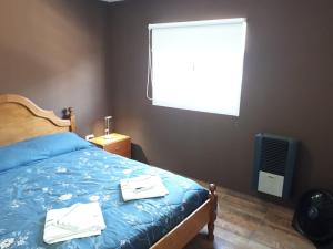 1 dormitorio con 1 cama con 2 toallas en alquilerpordiviedma en Viedma