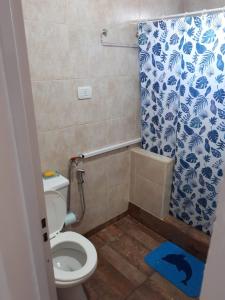 baño con aseo y cortina de ducha azul y blanco en alquilerpordiviedma en Viedma