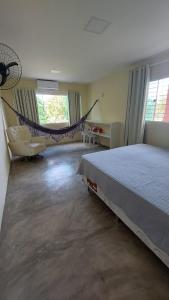 a bedroom with a bed and a hammock in it at Recanto ViVa - Catuama in Goiana