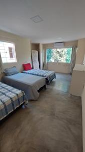 two beds in a room with two windows at Recanto ViVa - Catuama in Goiana