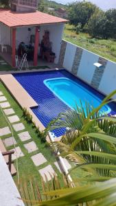 a swimming pool in front of a house at Recanto ViVa - Catuama in Goiana