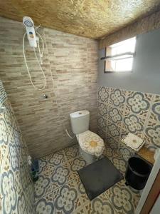 een kleine badkamer met een toilet en een raam bij Hostel Antônio Pescador Guarda do Embau in Guarda do Embaú