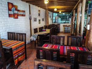 un restaurante con mesas y sillas en una habitación en Chuza Longa Home en Guamote