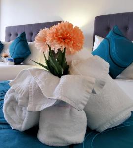 a bouquet of flowers on a bed with towels at Cairns Luxury Waterfront Apartment in Cairns