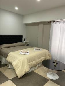 a bedroom with a bed and a table with towels on it at Depto en Monte Grande a 15 minutos del Aeropuerto 1 Zona Residencial con estacionamiento in Monte Grande