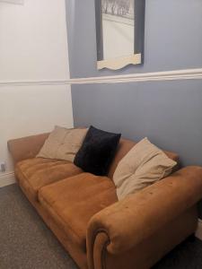 un divano marrone in soggiorno di The Vacationers - Pvt Rooms with Shared Bath a Sunderland