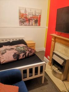 sala de estar con cama y chimenea en The Vacationers - Pvt Rooms with Shared Bath, en Sunderland