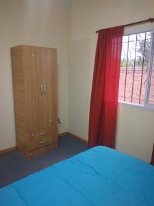 1 dormitorio con 1 cama, vestidor y ventana en Departamento mario en San Rafael