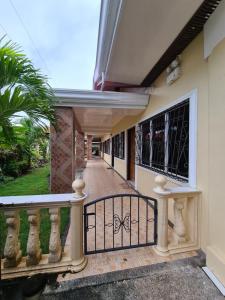 einen Balkon eines Hauses mit Tor in der Unterkunft La-Familia Guest House in Siquijor