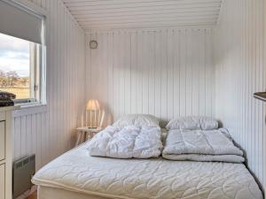a bed in a white room with a window at 5 person holiday home in Læsø in Læsø