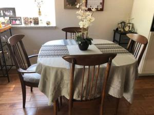 a dining room table with a vase of flowers on it at Clovis, CA National Parks Room in Clovis