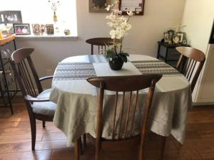 a dining room table with a vase of flowers on it at Clovis, CA National Parks Room in Clovis