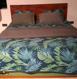 a bed with a blue and green blanket on it at Villa BAOBAB 