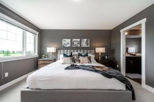 a bedroom with a large bed and a large window at Amazing Luxe Home, AC, HUGE Yard, FirePit, Pet Friendly, Sleeps 10! in Edmonton