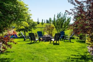 a group of chairs and a table in a yard at Amazing Luxe Home, AC, HUGE Yard, FirePit, Pet Friendly, Sleeps 10! in Edmonton