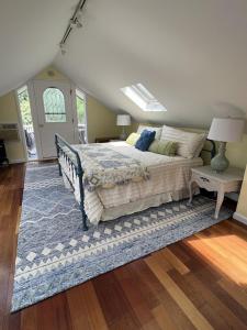 1 dormitorio con 1 cama con alfombra azul en New Listing ! Captain's Cottage - Cold Spring Harbor Water Views, 