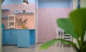 uma cozinha de brinquedo com um armário azul e uma parede rosa em Moc Thach Blue House DaLat em Da Lat
