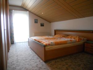 sypialnia z dużym łóżkiem i drewnianym sufitem w obiekcie Ferienwohnungen/Holiday Apartments Lederer w mieście Reisach