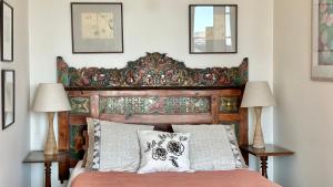 a bed with a wooden headboard and two lamps at The Whitestone in Oamaru