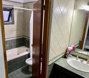 a bathroom with a sink and a tub and a toilet at Departamento Excelente Ubicación. Zona Arístides y Parque. in Mendoza