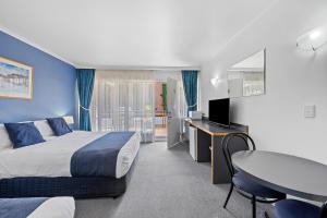 um quarto de hotel com uma cama, uma secretária e uma mesa em The River Boat Hotel - Echuca em Echuca