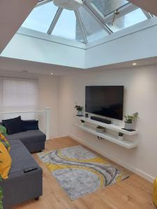 a living room with a couch and a flat screen tv at 1 bedroom modern duplex in Southampton