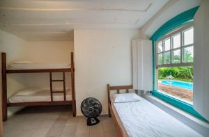 a room with two bunk beds and a window at Casa Viva Paraty in Paraty