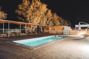 una piscina por la noche con bancos alrededor en Peumayen Atacama cabaña&Hostal, en San Pedro de Atacama