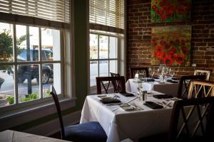 a dining room with tables and chairs and windows at The Marshall House, Historic Inns of Savannah Collection in Savannah