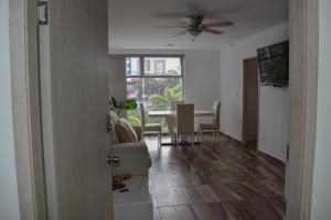 uma sala de estar com uma mesa e uma ventoinha de tecto em Acogedor Apartamento, excelente ubicación. Pereira em Pereira