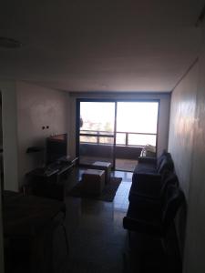 sala de estar con sofá y ventana grande en Flat na Beira Mar Mucuripe, en Fortaleza