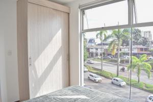 1 dormitorio con cama y ventana grande en Acogedor Apartamento, excelente ubicación. Pereira, en Pereira