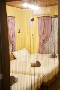 うるま市にあるカシェットのベッドルーム(ピンクのカーテンが付いた白いベッド付)
