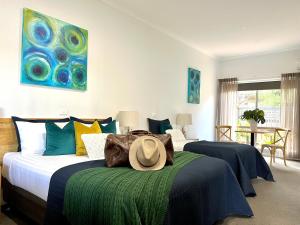 - une chambre avec 2 lits et un chapeau sur le lit dans l'établissement Coastal Waters Motor Inn, à Lakes Entrance