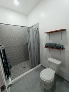 a bathroom with a shower and a white toilet at Your Bedroom in Puerto Peñasco